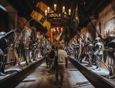 Les visiteurs déambulent dans la salle des armures du spectacle immersif "La Renaissance du Château"
