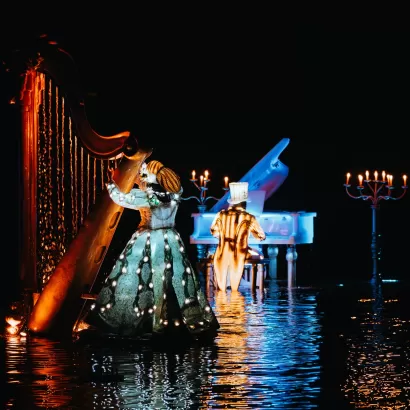 Une violoniste et un pianiste sur l'eau au spectacle nocturne les Noces de Feu au Puy du Fou