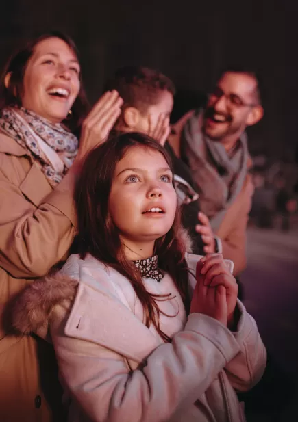 Famille avec enfants profitant de son séjour au Puy du Fou avec un final devant le spectacle nocturne "Les Noces de Feu" 