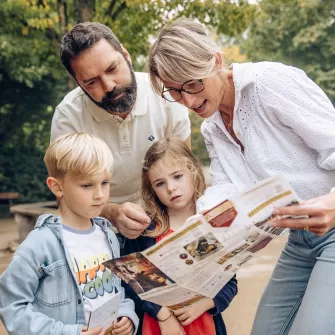 Famille qui regarde le programme pour trouver les horaires des spectacles du Puy du Fou