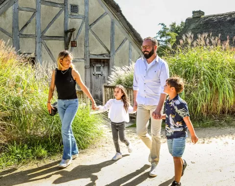 La famille se balade devant les huttes de l'hôtel "Les Iles de Clovis"