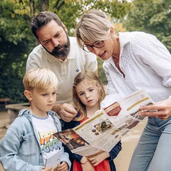 Famille devant un Guide Visiteur lors de son séjour au PDF