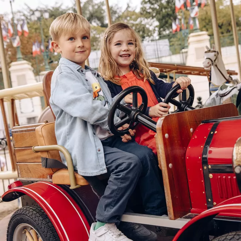 Deux enfants en voiture dans le Parc