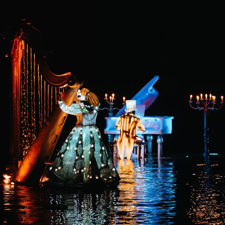 Une violoniste et un pianiste sur un lac dans le spectacle nocturne les Noces de Feu