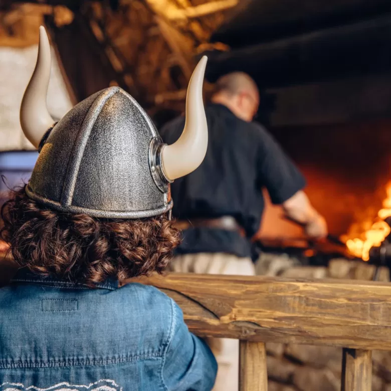 Petit garçon avec un casque des Vikings devant le forgeron du village Chasseloup