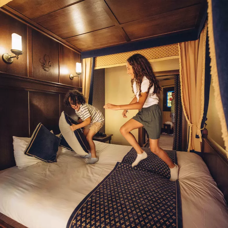 Enfants sautant sur un lit de la Cité Nocturne