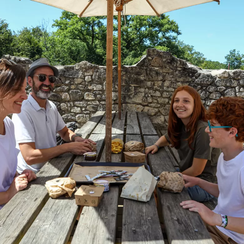 Famille rassemblée autour d'une table au Rendez-Vous des Ventres Faims pour déguster de délicieux burgers.