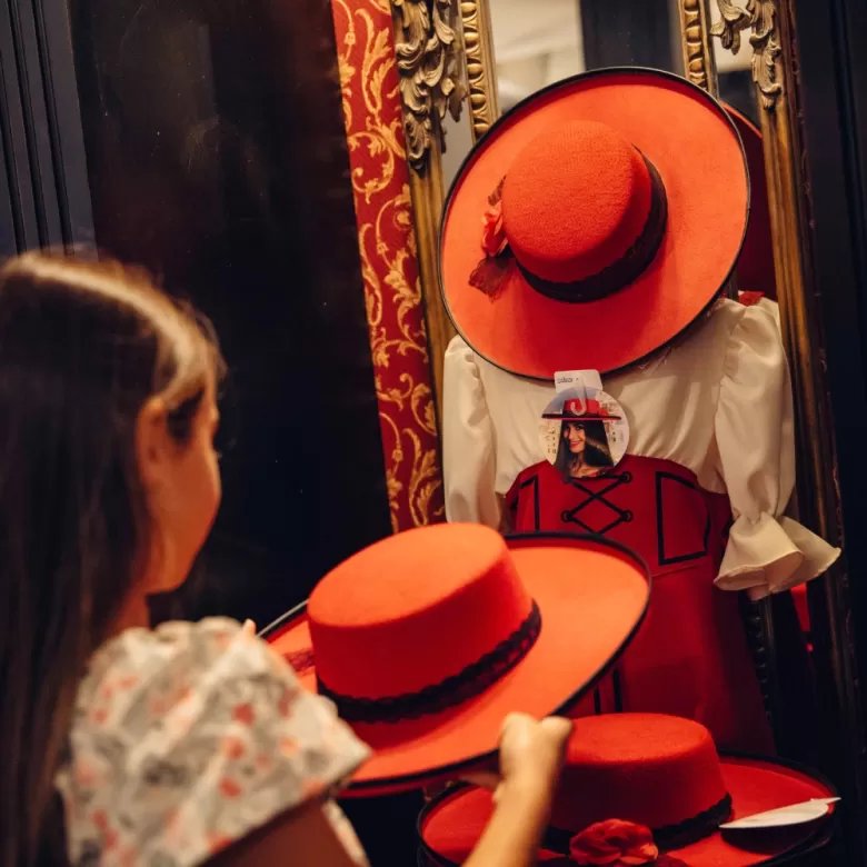 Jeune fille devant le costume de la Serafina dans une boutique du Puy du Fou