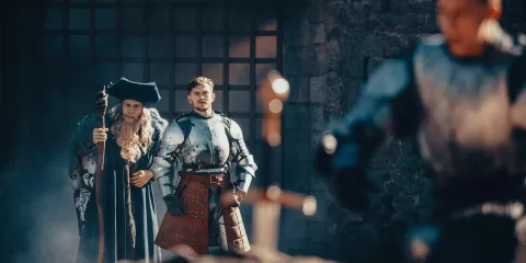 Merlin et Arthur regardant un chevalier en train d'essayer de retirer Excalibur