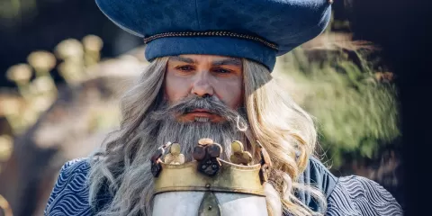 Merlin l'enchanteur avec un casque dans ses mains