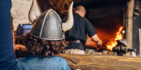 Enfant en costume de Vikings devant le forgeron