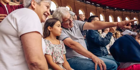 Grands-parents avec une petite fille devant le spectacle du Signe du Triomphe