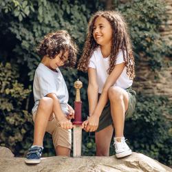 Des enfants tentent de soulever l'épée Excalibur de son rocher dans le village Font-Rognou.
