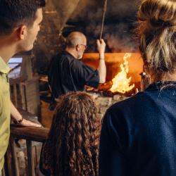 Une famille regarde le travail du forgeron à Saint-Philbert-le-Vieil.