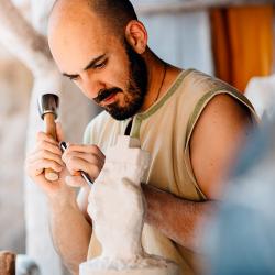 Un sculpteur au savoir-faire ancestral travaille dans le village Font-Rognou.