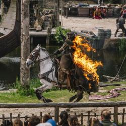 Un viking sur un cheval enflammé traverse la scène du spectacle "Les Vikings"