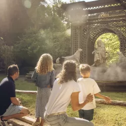 Une famille devant la statue de Jean de la Fontaine dans le spectacle nature "Le Monde Imaginaire de la Fontaine"